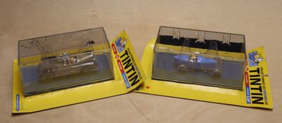 two model cars that are in a box on a table