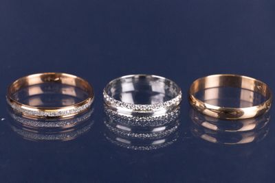 trois bagues en or et en argent serties de diamants sur un fond noir