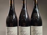 three bottles of wine are lined up on a table