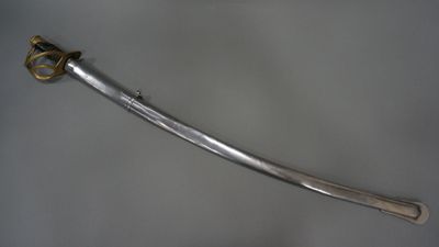 a close up of a sword on a table with a white background