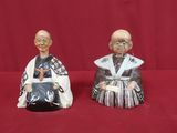 paire de figurines asiatiques représentant un homme et une femme sur fond rouge