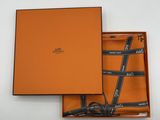 une boîte orange contenant une cravate et une paire de lunettes
