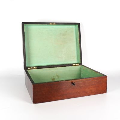 une petite boîte en bois avec un couvercle vert posée sur une surface blanche