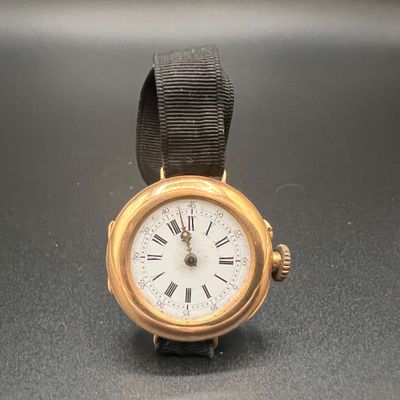 une montre en or avec des chiffres romains sur le cadran