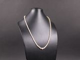 un collier de perles blanches sur un mannequin noir