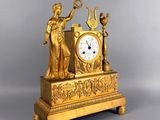 a gold clock with a statue on top of it