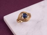 an image of a gold ring with a blue stone in the center