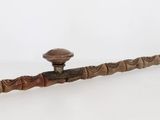 une pipe avec un manche en bois posée sur une surface blanche
