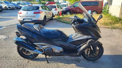 une moto noire garée sur un parking à côté de voitures