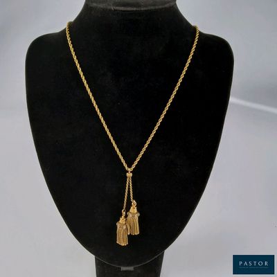 un collier en or orné d'un pompon, suspendu à un mannequin