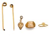 une photo présentant une collection de bijoux en or, comprenant une épingle, une broche et une bague