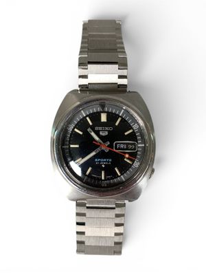une montre posée sur une surface blanche