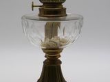 une lampe à huile ancienne en laiton et en verre sur fond blanc