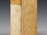 an old book sitting on top of a white table next to a gray wall