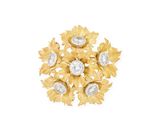 a close up of a gold and diamond broochle on a white background