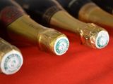 several bottles of wine are lined up on a red cloth