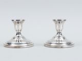 pair of silver candlesticks on a white background