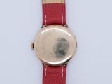 a close up of a watch on a white surface