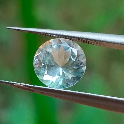 un gros plan d'un diamant tenu par une pince