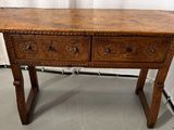 une vieille table en bois surmontée de deux tiroirs