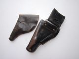 pair of leather holsters on a white surface with a white background