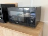 two microwaves sitting on top of a wooden shelf
