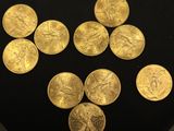 six gold coins are arranged in a triangle on a black surface