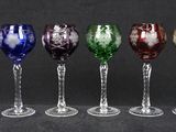 six different colored wine glasses are lined up in a row