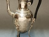 an antique silver tea pot with a handle and handle on a stand
