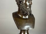 bronze bust of a man with curly hair and a beard