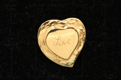 a gold heart with the word love written on it