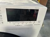 a white washing machine sitting on top of a counter
