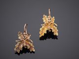 a pair of gold earrings with leaves and flowers
