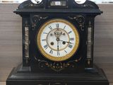 a black and gold clock sitting on a wooden table