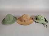 three hats are lined up in a row on a white surface