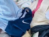 a metal basket filled with clothes and clothing on the floor