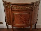 a wooden cabinet with a marble top on a hard wood floor