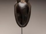 a wooden sculpture of a rabbit ' s head on a stand