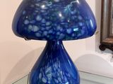 une table en verre sur laquelle est posée une lampe bleue