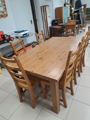 a large wooden table and chairs in a room
