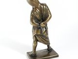 bronze figurine of a man with a bag on his back