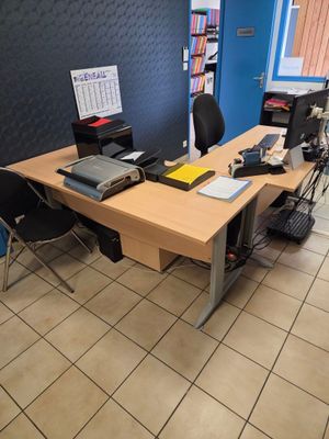 un bureau sur lequel sont posés un ordinateur portable et un écran, dans une pièce