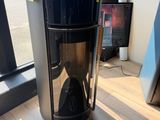 une cafetière posée par terre devant une fenêtre