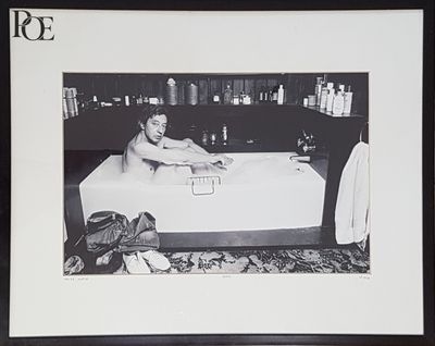 photographie en noir et blanc d'un homme en train de prendre un bain dans une baignoire