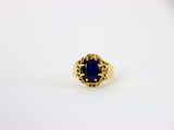 une bague en or avec une pierre bleue au centre