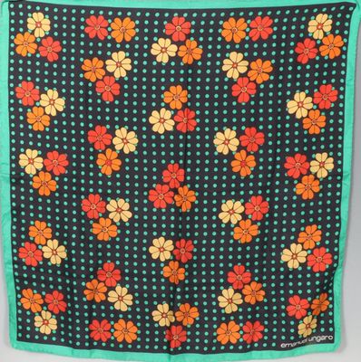 une écharpe à motifs floraux noirs et orange, bordée de vert