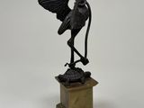 an image of a bronze statue of a crane on a pedestal