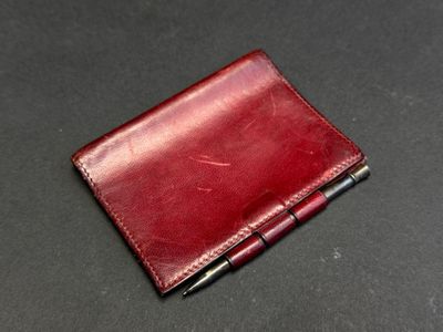 leather wallet with pen on a black surface