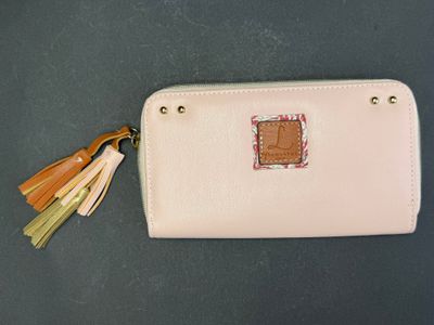 a close up of a pink purse with a tassel on it
