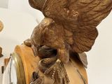 a statue of a bird sitting on top of a clock